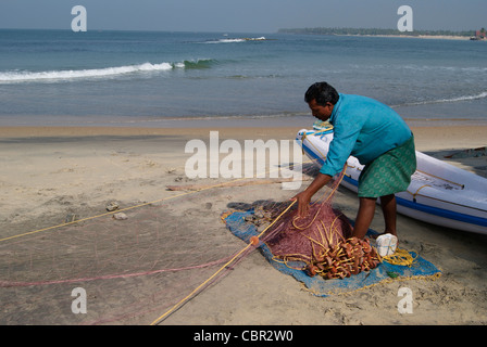 Fisherman preparare la sua nativa delle reti da pesca Foto Stock