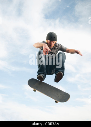 Uomo caucasico su skateboard in mid-air Foto Stock