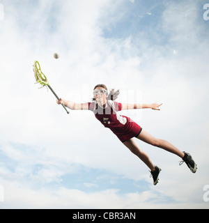 Adolescente caucasica a mezz aria riproduzione di lacrosse Foto Stock