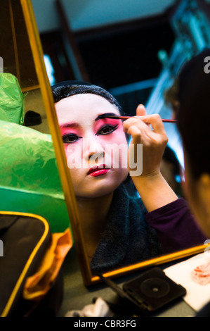 Un opera cinese performer mettendo il trucco in spogliatoio. Foto Stock