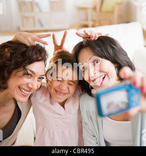 Famiglia tenendo autoritratto con fotocamera digitale Foto Stock