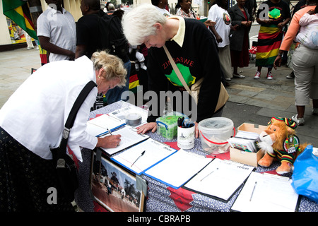 La firma di una petizione di protesta contro il Presidente Mugabe nello Zimbabwe e in Londra Foto Stock