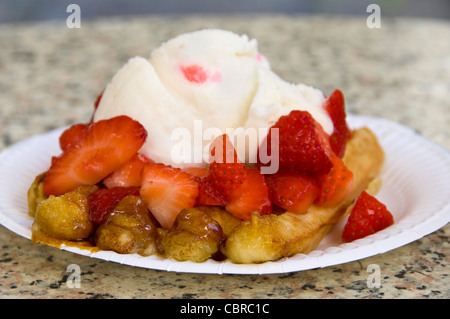 Chiudere orizzontale di una cucinata fresca cialda di Liegi soffocato in fragole fresche e clotted cream. Foto Stock