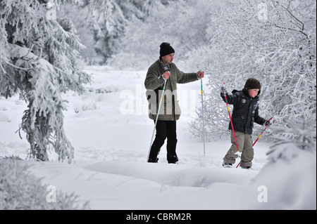 Padre figlio di insegnamento Nordic sci di fondo / langlauf in inverno nella neve a riserva naturale Hautes Fagnes, Belgio Foto Stock