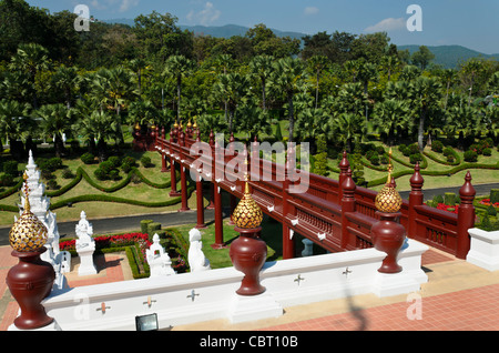 La vista dal balcone del Royal Pavilion al Royal Flora Ratchaphruek in Chiang Mai Thailandia di legno ponte pedonale e palme Foto Stock