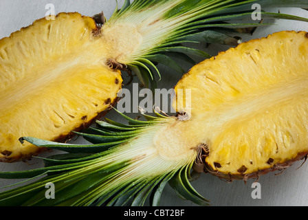 Ananas tagliato a metà su sfondo bianco Foto Stock