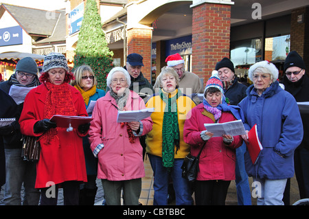 Coro per adulti a cantare i canti natalizi, due fiumi Shopping Centre, Staines-upon-Thames, Surrey, England, Regno Unito Foto Stock