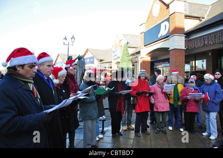 Coro per adulti a cantare i canti natalizi, due fiumi Shopping Centre, Staines-upon-Thames, Surrey, England, Regno Unito Foto Stock