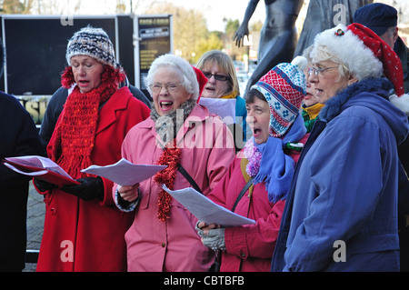 Coro per adulti a cantare i canti natalizi, due fiumi Shopping Centre, Staines-upon-Thames, Surrey, England, Regno Unito Foto Stock