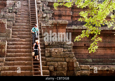 I turisti lentamente scendendo le ripide scale di pietra del Tempio Phimeanakas, Angkor Thom, Cambogia Foto Stock