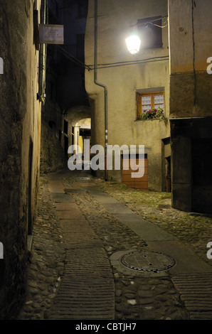 Vicolo scuro illuminato da luce di strada singola o lampada di notte, città vecchia di Tende, valle di Roya, Alpi Marittime, Francia Foto Stock