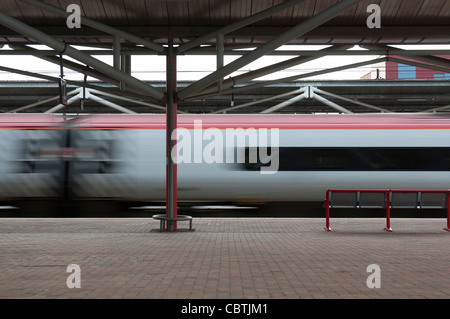 Vergine treno pendolino passando attraverso il Rugby stazione ferroviaria ad alta velocità, Warwickshire, Regno Unito Foto Stock