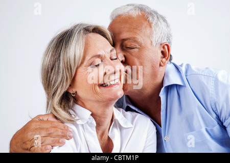 Senior uomo dando la sua moglie bacio sulla guancia Foto Stock