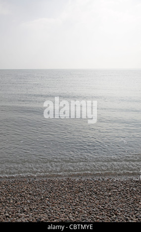 Grigio calme acque del Mare del Nord con dolci onde su ancora un giorno, da Shingle Street, Suffolk, Inghilterra Foto Stock