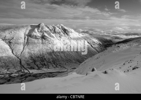 Immagine in bianco e nero di sole d'inverno sulle Langdale Pikes nel Lake District inglese Foto Stock