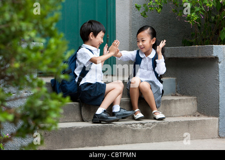 Scuola di due bambini che giocano al di fuori Foto Stock