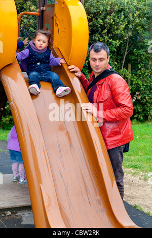 Padre e figlia su un parco giochi slitta Foto Stock