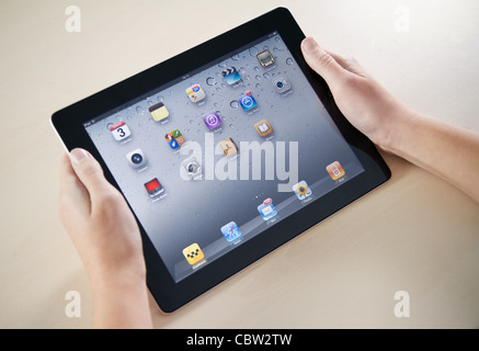 Donna mani Apple iPad2 con homepage su uno schermo. Foto Stock