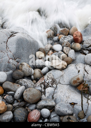 Dettaglio di un'onda correre su di una spiaggia di ciottoli in Galles. Foto Stock