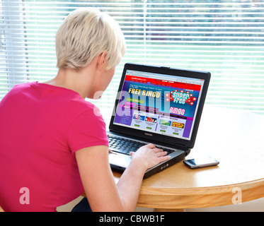 Donna giocando online giochi bingo su Ladbrokes sito web Foto Stock