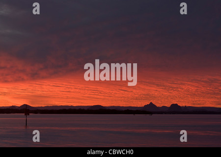 Tramonto dietro la Glasshouse Mountains, con Pumicestone passaggio in primo piano Foto Stock