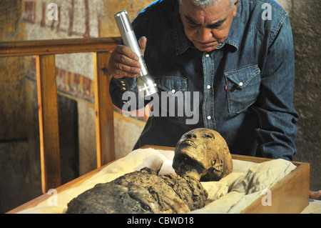 Zahi Hawass esaminando King Tut mummia dentro la tomba di Re Tut nella Valle dei Re a Luxor, Egitto Foto Stock