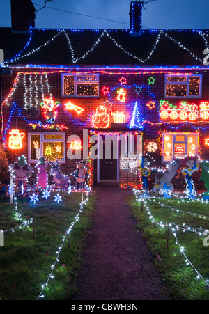 L'esterno di una casa illuminata con le luci di Natale al crepuscolo Home Immobili illuminato decorazioni di Natale di notte Foto Stock