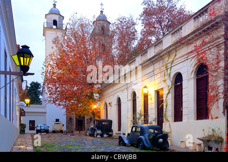 La vecchia strada a Colonia del Sacramento, con la vecchia auto e la cattedrale. Uruguay, Sud America. Foto Stock