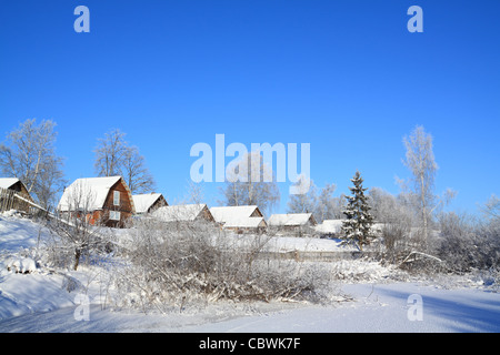 Villaggio in neve sul fiume costa Foto Stock