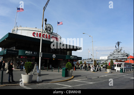 Blue sky view, USS Intrepid, asfalto, persone, bandierine americane, Circle Line ticket edificio, Pier 83, West 42th Street, New York Foto Stock