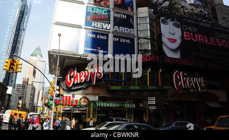 Blue sky angolo di strada cartelloni, automobili, persone, negozio di generi alimentari, Chevys, Villa Ristorante Pizzeria, West 4nd Street 8th Avenue, New York Foto Stock