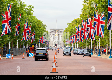 Automobili e biciclette la guida e i pedoni a camminare sul Mall di fronte a Buckingham Palace. Foto Stock