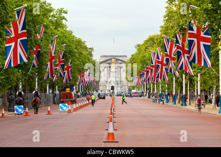 Automobili e biciclette la guida e i pedoni a camminare sul Mall di fronte a Buckingham Palace. Foto Stock