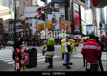 Visualizzazione delle persone, cartelloni, animatori (Minnie Mouse, Shrek, SpongBob) in piedi il marciapiede, settima Avenue West 48th Street, New York Foto Stock