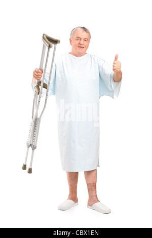 A piena lunghezza Ritratto di un paziente senior holding stampelle e dando pollice in alto Foto Stock