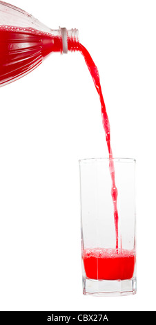 Succo rosso che viene versato in un bicchiere su sfondo bianco Foto Stock