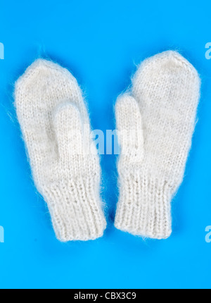 Una coppia di maglia di lana guanti su uno sfondo blu Foto Stock