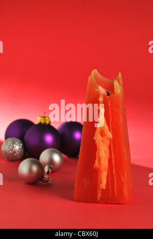 Una candela rossa con baubles di Natale Foto Stock