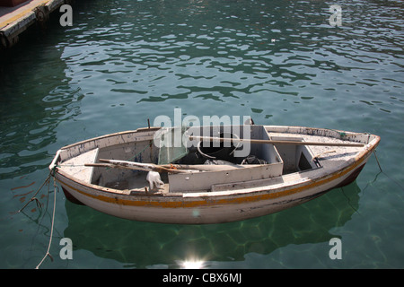 Piccole casette di legno barca da pesca collegato al dock sul isola di Capri in scintillanti di acqua color smeraldo su una luminosa e soleggiata giornata. Foto Stock