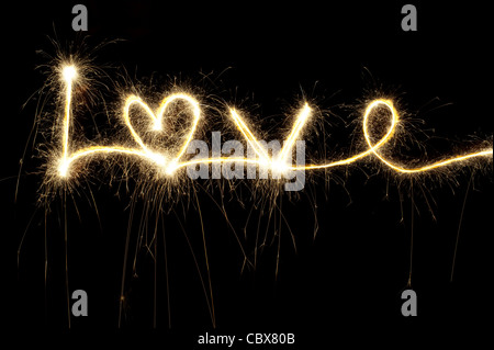 Amore scritte con un sparkler a notte compresa una forma di cuore Foto Stock