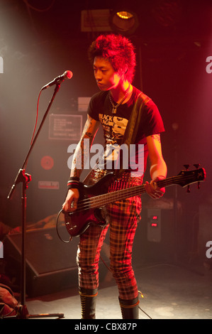 Pechino, MAO Livehouse. Qian Han a suonare il basso sul palco durante un concerto del suo street punk band "perché". Foto Stock