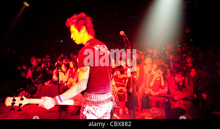 Pechino, MAO Livehouse. Qian Han a suonare il basso sul palco durante un concerto del suo street punk band "perché". Foto Stock