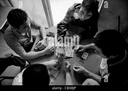 Pechino, vicino Dongfeng park. L'uomo gioca un serio gioco di carte con high stakes. Foto Stock
