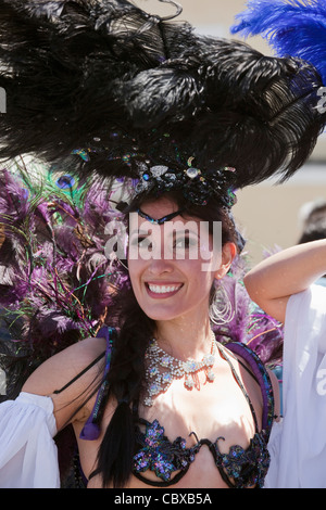 Donna in selvaggina di penna copricapo e strass collana partecipa al Carnevale annuale nel distretto di missione di San Francisco, California Foto Stock