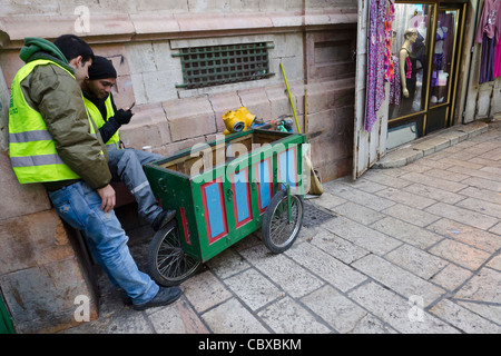 Due palestinesi street pulitori con trolley per le strade di Gerusalemme vecchia città. Israele Foto Stock