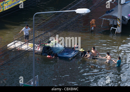 Gli uomini Thai provare a tirare un pick-up truck attraverso il diluvio, Rangsit, un sobborgo a nord di Bangkok, Thailandia. Credito: Kraig Lieb Foto Stock