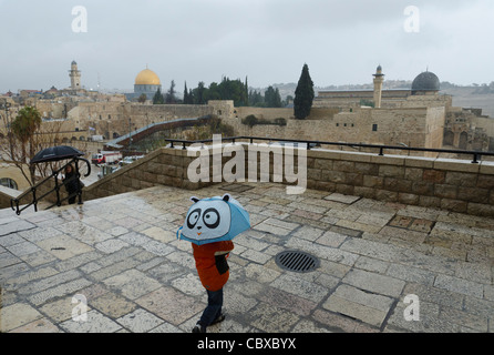 Bambino con ombrellone con ,moschee e muro occidentale in bkgd. Gerusalemme vecchia città. Israele Foto Stock