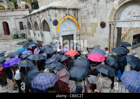 Pellegrini cristiani a III stazione della Via crucis, in un giorno di pioggia. Gerusalemme vecchia città. Israele Foto Stock