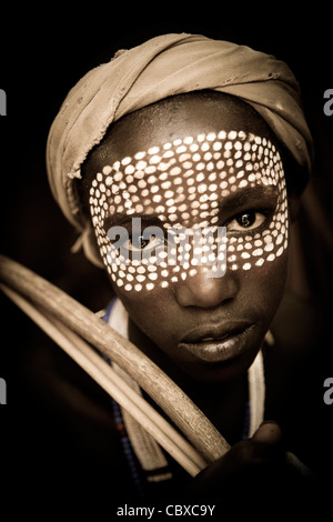 Suggestivo ritratto di una giovane ragazzo con una faccia dipinta dall'Arbore tribù nella bassa valle dell'Omo, l'Etiopia meridionale, Africa. Foto Stock