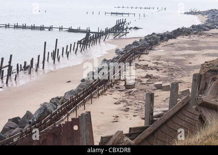 Happisburgh Beach, North Norfolk. Mostra le successive linee di difesa brakewater; legno, rocce importate e pennelli di metallo. Foto Stock